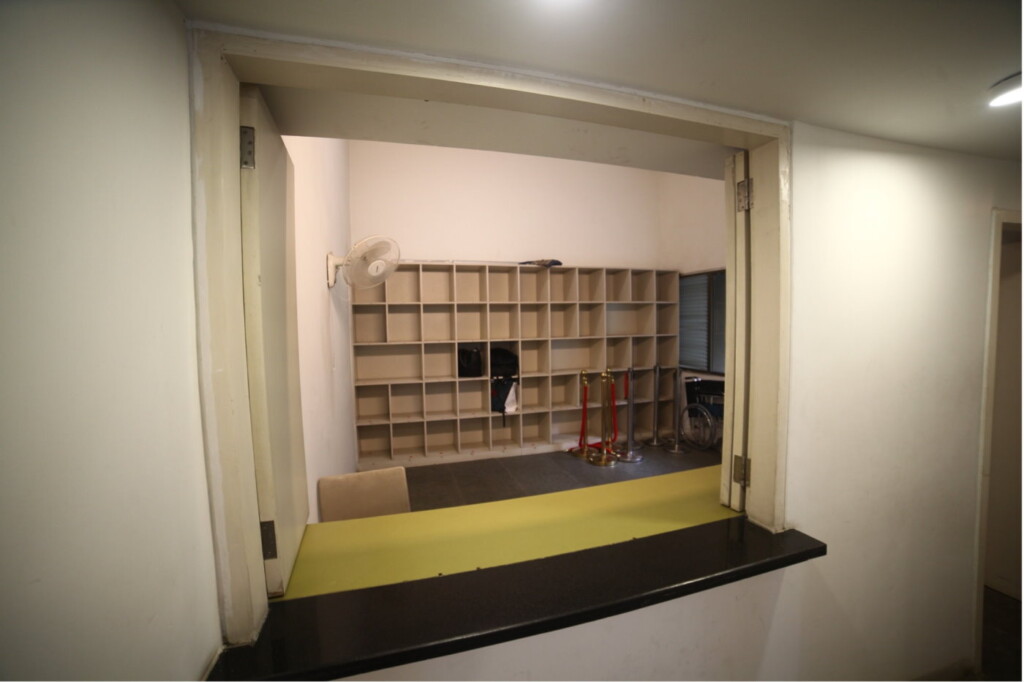 This is our cloak room. You may leave any heavy bags, dripping umbrellas or raincoats over here. They will be safe. Please do not forget to collect them on your way back.